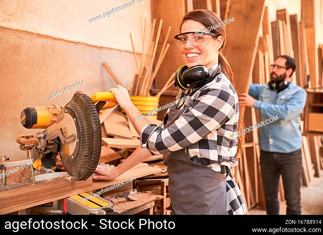 Junge Frau als Handwerker Lehrling an der Kappsäge in der Tischlerei Werkstatt