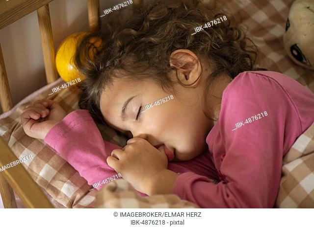 Girl, 3 years, portrait, sleeps in bed, with thumb in mouth, Germany, Europe