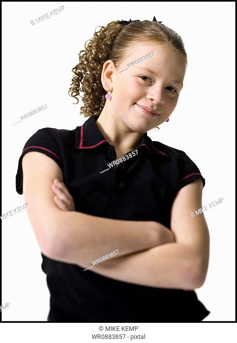 Portrait of a teenage girl standing with her arms crossed