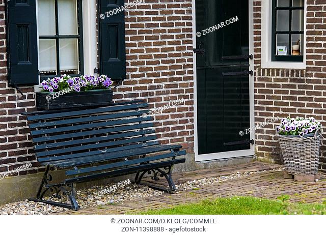 Giethoorn, The Netherlands - May 19., 2016: Violet flowers at the door of a monumental house in the small, picturesque town of Giethoorn, Overijssel