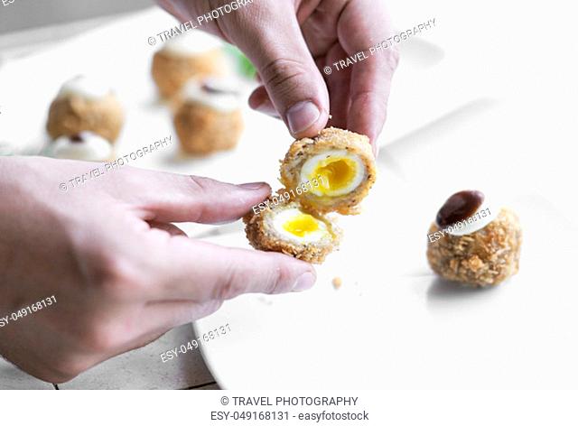 man opening gourmet organic scotch quail eggs modern starter snack dish