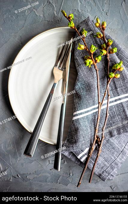 Spring table setting in rustic style decorated with cherry bloom tree branches