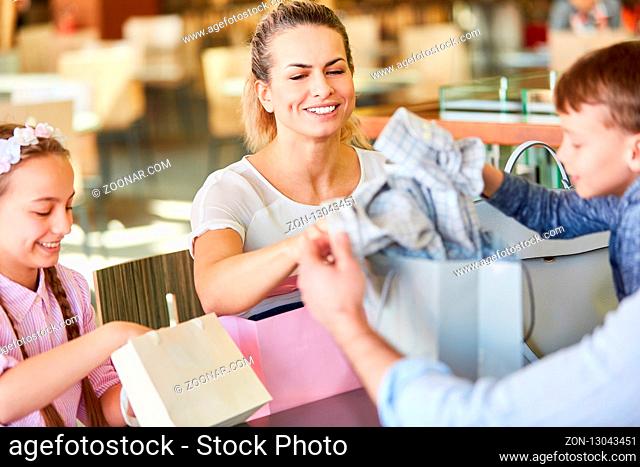 Familie mit zwei Kindern macht Pause beim Shopping im Einkaufszentrum
