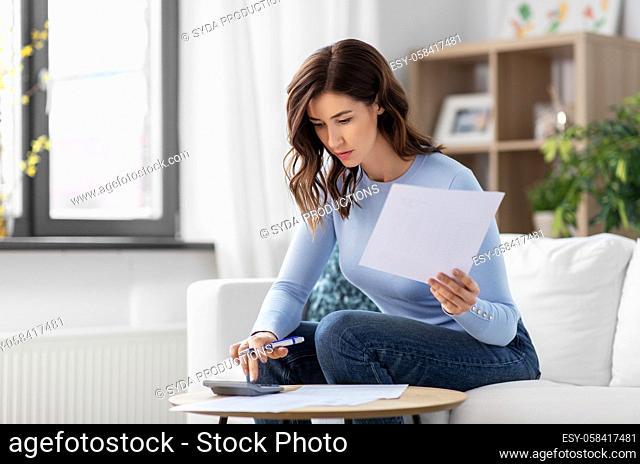 woman with papers and calculator at home