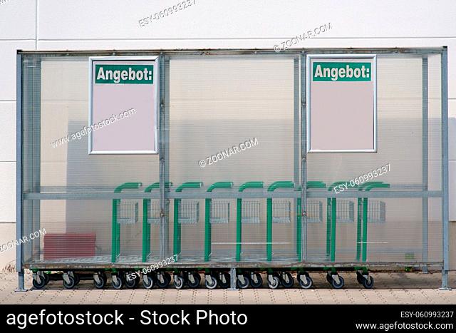Ein Kunststoffunterstand mit Rollwagen außen vor dem Eingang eines Getränkehändlers