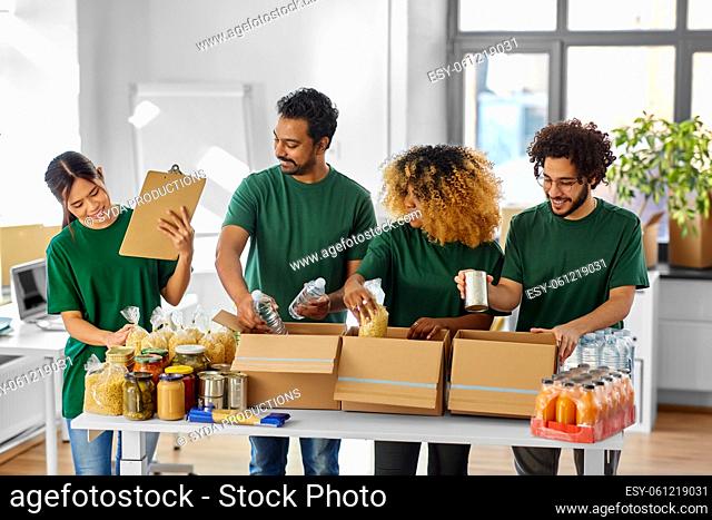 happy volunteers packing food in donation boxes