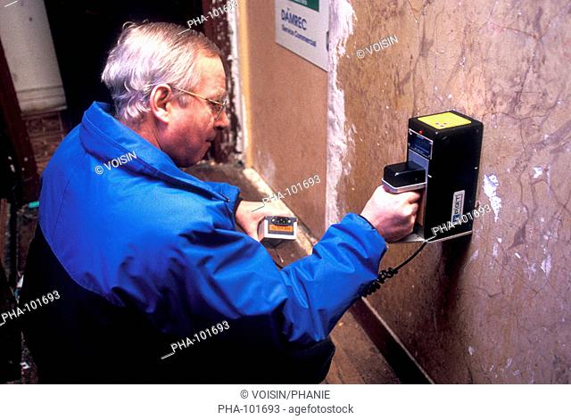 Prevention of lead poisoning diseases : technician measuring lead content in the painted surfaces from deteriorated lead-paints