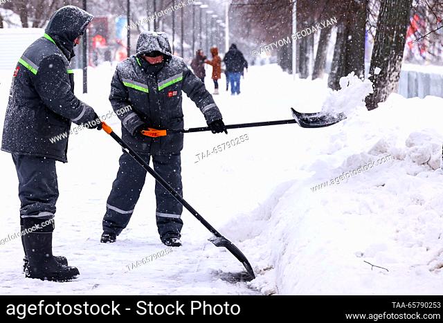RUSSIA, MOSCOW - DECEMBER 15, 2023: Street cleaners shovel snow at the VDNKh exhibition centre and park. Artyom Geodakyan/TASS