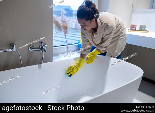 Cleaning. A woman doing cleaning at home and disinfecting the bathroom