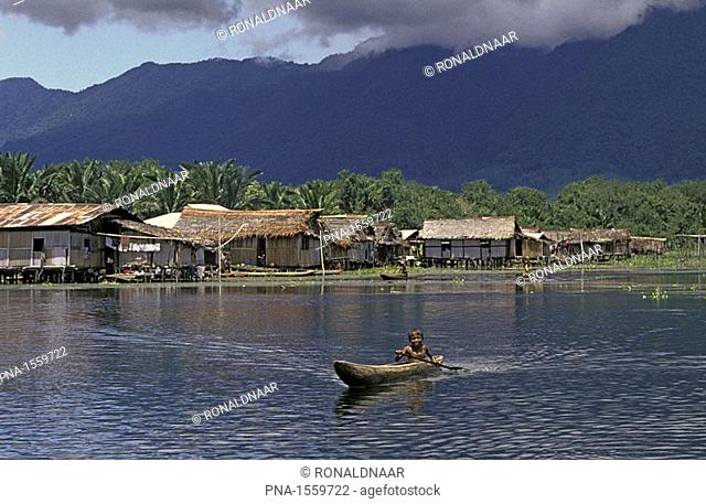 Lake near Jayapura with Papua boy canoeing, New-Guinea, Indonesia