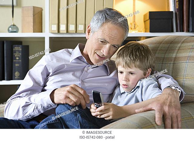 Man and grandson with cell phone