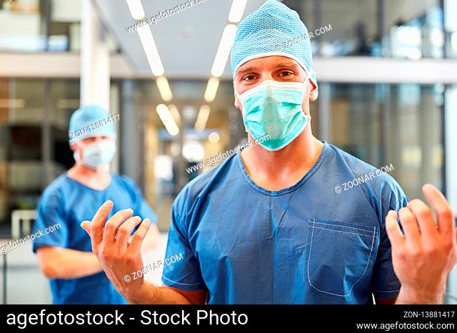 Mann als Chirurg mit Kompetenz in blauer OP-Kleidung in der Intensivstation der Klinik