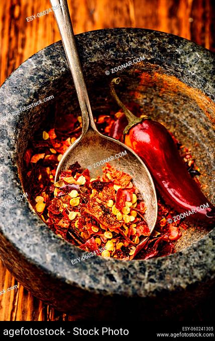 Crushed red chili pepper in stone mortar