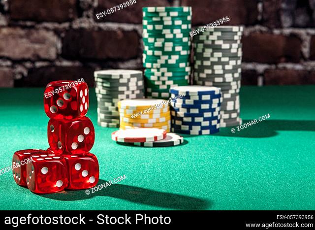 Red dice and chips on green table with shadow