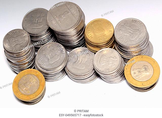 Stock pile of 5 and 10 Indian rupee metal coin currency on isolated white background. Financial, economy, investment concept
