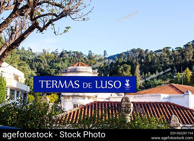 Horizontal photo of a blue sign of Termas de Luso, since 1852, with the Grande Hotel de Luso behind