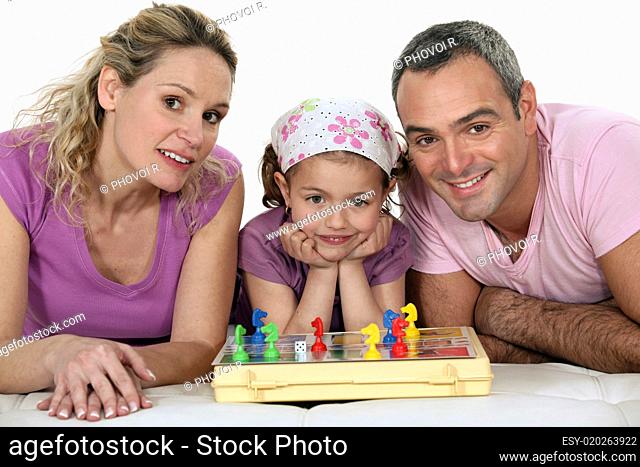 Parents and little girl playing chess together