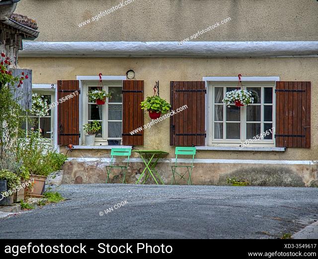 green table and two green chairs in front of a house, Issigeac, Dordogne Department, Nouvelle-Aquitaine, France