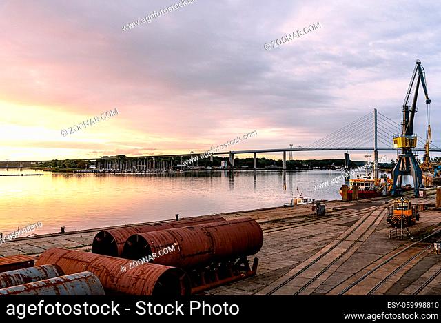Panoramic view of the commercial harbour of Stralsund with cranes at sunrise against the bridge to the island of Rugen