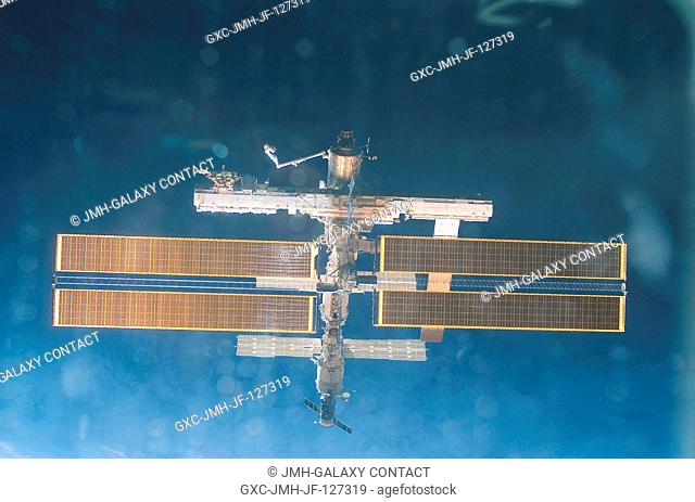 Backdropped by the blackness of space, this full view of the International Space Station (ISS) was photographed by a crewmember on board the Space Shuttle...