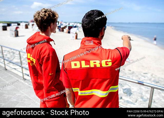 15 June 2022, Lower Saxony, Hooksiel: Two lifeguards of the DLRG guard the North Sea beach of Hooksiel in sunny weather. Wilhelmshaven is hosting the North Sea...
