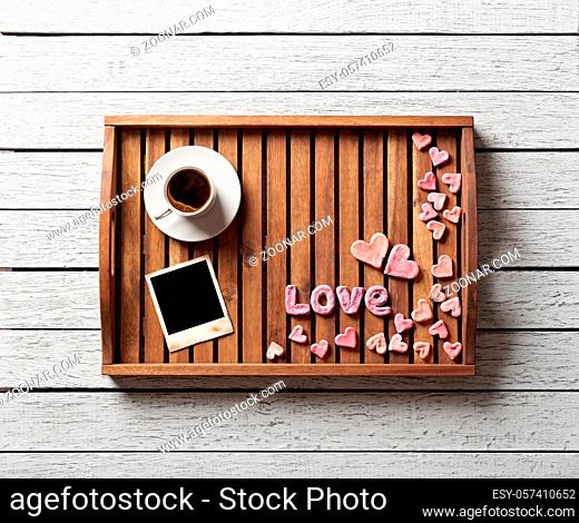 Cute valentine#39;s items on salver: small hearts, blank photo frame, word love and cup of coffee