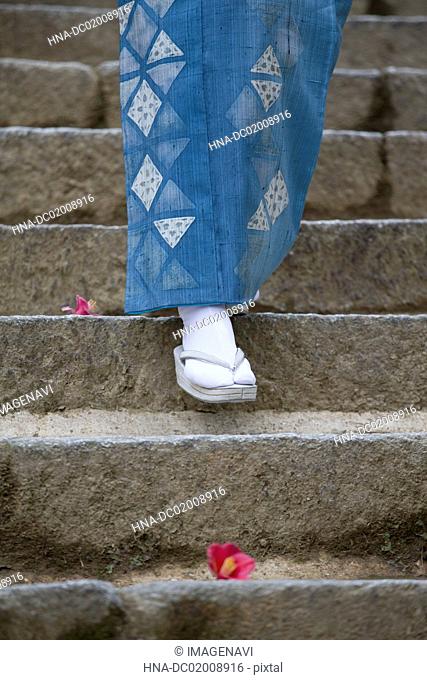 Woman's feet in kimono with Zouri (Japanese sandals) on stone stairs