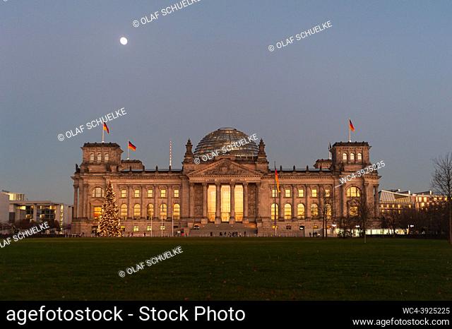 Berlin, Germany, Europe - The evening light is reflected in the windows of the Reichstag building (Imperial Diet) in the Mitte district while the moon shines...