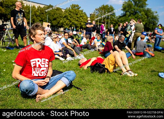12 September 2020, Lower Saxony, Hanover: A demonstrator meditates during a demonstration against the Corona measures in the city centre
