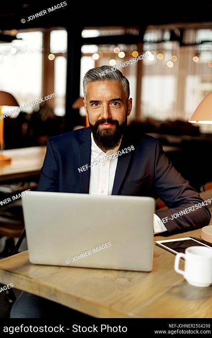 Businessman in cafe looking at camera