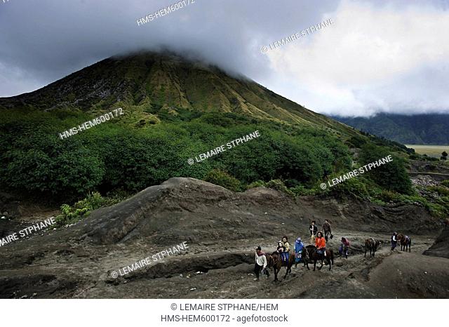 Indonesia, Java, East Java Province, Bromo Tengger Semeru National Park, horsemen bring tourist on top of Gunung Bromo Crater