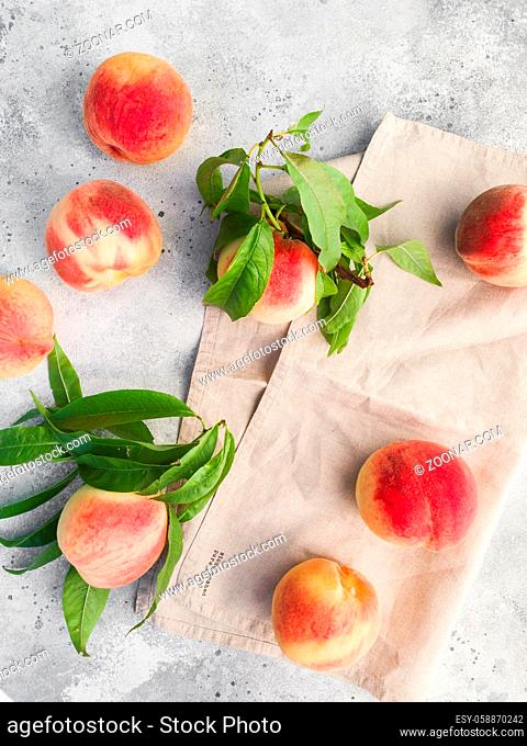Several ripe juicy peaches on a gray background. Peach fruits on the wooden board. Green living concept. Organic food