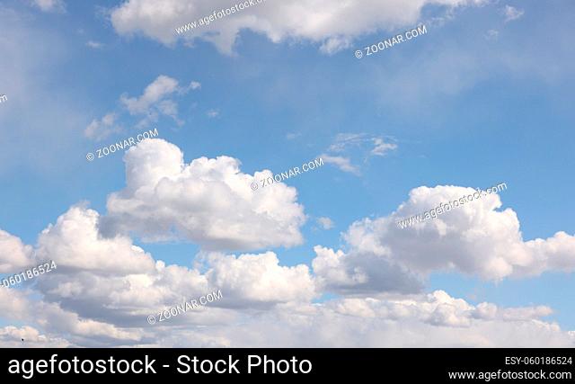 Beautiful cloudscape with bright white clouds over blue sky, low angle view