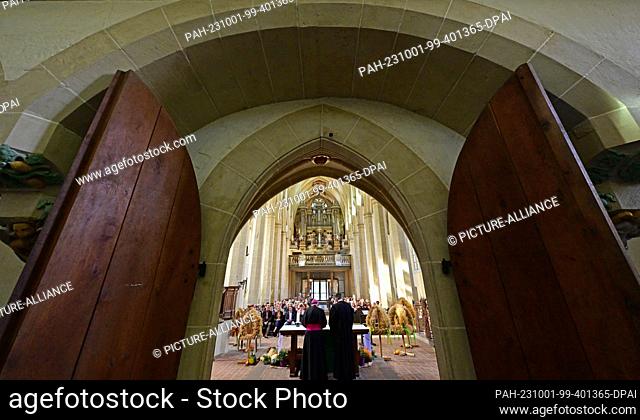 01 October 2023, Thuringia, Erfurt: Harvest crowns stand next to the altar in Erfurt's Predigerkirche. Thuringia celebrates the harvest festival with an...