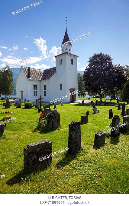 Ulvik church with blue sky, flowers and graves in the summer, Hardangerfjord, Hordaland, Norway, Scandinavia