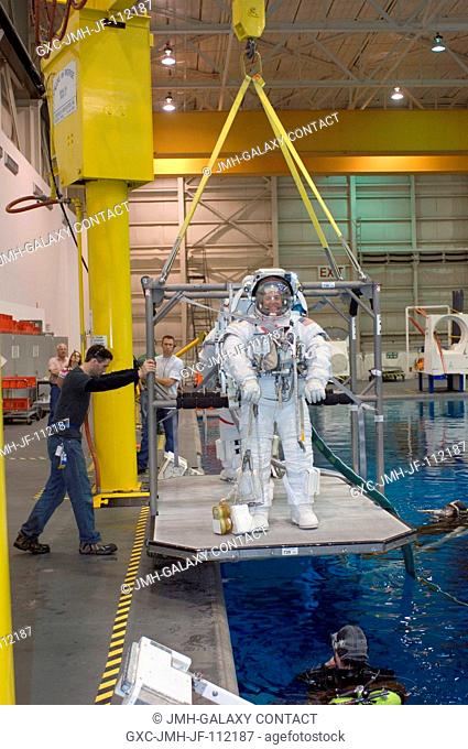 Astronauts Ronald J. Garan and Michael E. Fossum (partially obscured), both STS-124 mission specialists, are about to be submerged in the waters of the Neutral...
