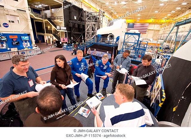 STS-133 crew members participate in a photoTV training session in the Space Vehicle Mock-up Facility at NASA's Johnson Space Center