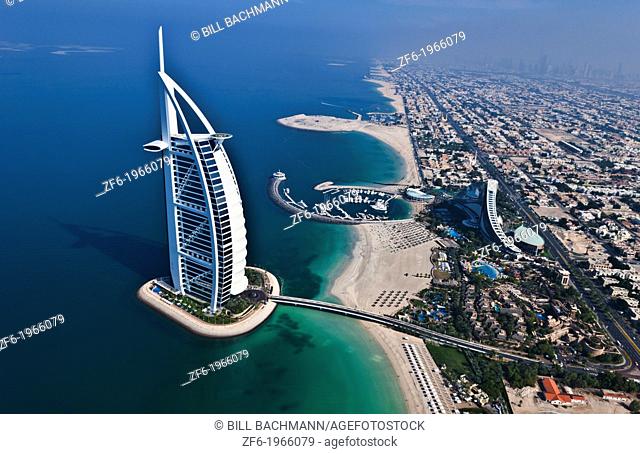 Worlds only 7 star hotel in Dubai UAE called the Burj Al Arab from helicopter above aerial with luxury and water at beach in United Arab Emirates