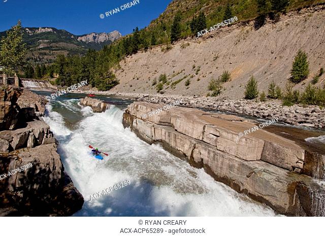 A male kayaker runs the challenging section of the Upper Elk River, Fernie, BC