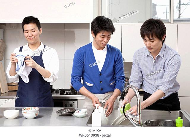 Three men washing dishes