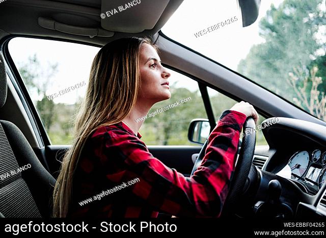 Beautiful young woman driving in car
