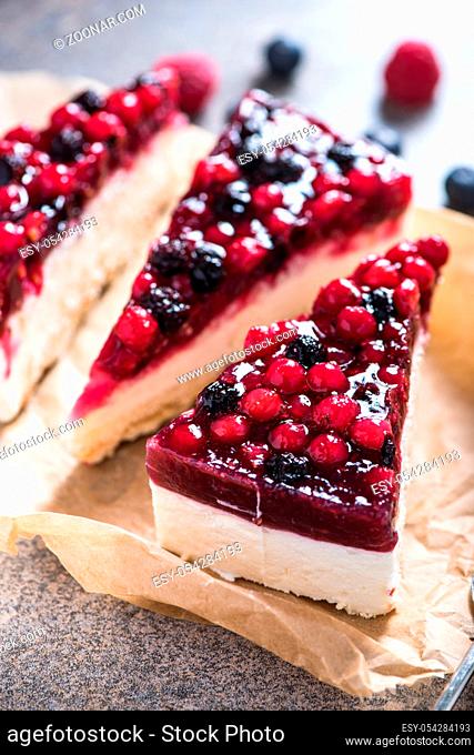 Simple mascarpone cheesecake with winter berry forest fruits, serving slices