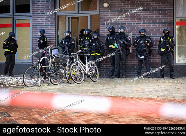 30 November 2023, Lower Saxony, Lehrte: Police officers are deployed in a cordoned-off area in front of a job center. The police have arrested a suspect who is...