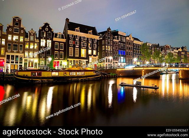 Amsterdam, Netherlands - April 20, 2017: Picturesque canal in Amsterdam. Beautiful night city view