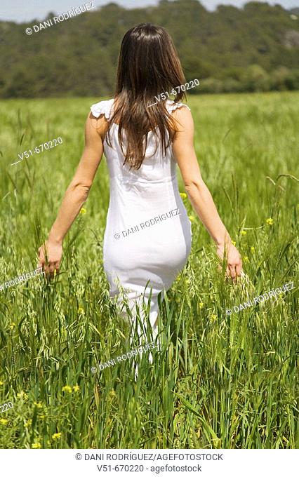 Woman in white dress walking in the countryside