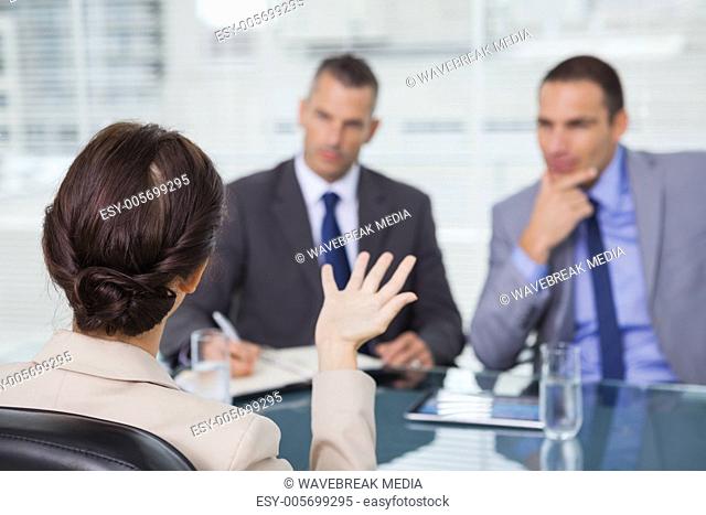 Brown haired woman talking to her interviewers