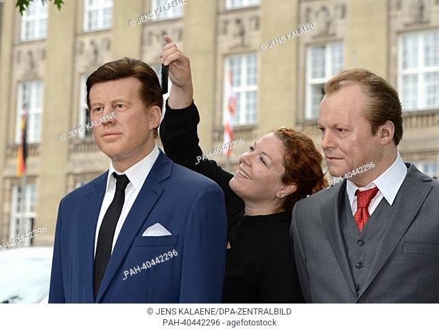 Media representative Nina Zerbe (C) works on the Madame Tussaud's wax figures of former US President John F. Kennedy (L) and former German Chancellor Willy...