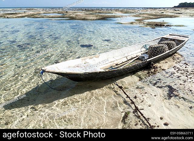 Abandoned boat at the seagrass plantation with blue water, Nusa Lembongan, Bali, Indonesia