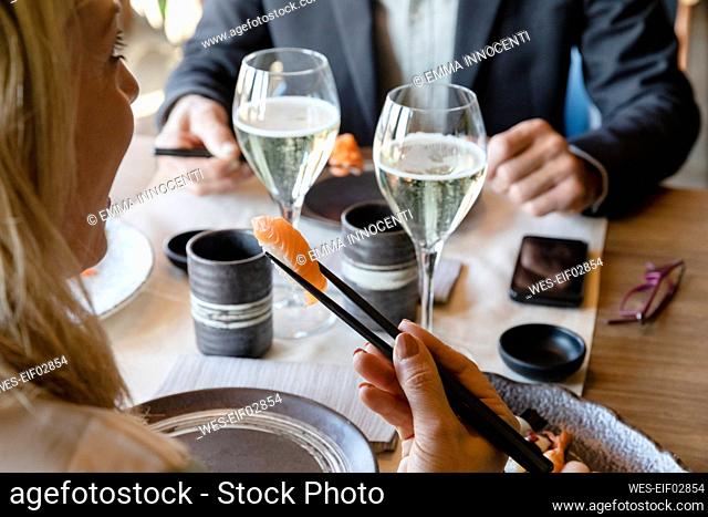 Man and woman eating sushi at lunch date in restaurant