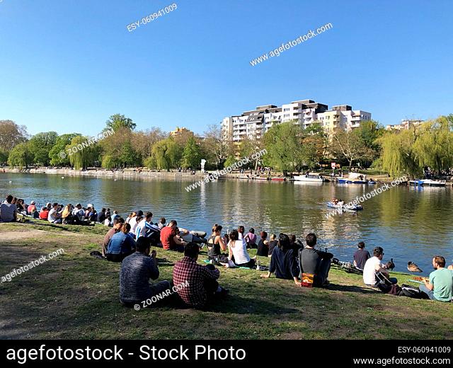 Berlin, Germany - april 2019: People enjoying sunny weather on the street, sitting at riverside in Berlin, Kreuzberg during spring